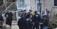 <p>Policiais em frente à casa em que avô atirou em neto e matou mulher a tiros, em Nova York</p>  Foto: AP