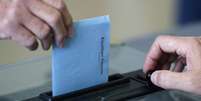 <p>Cidadão francês deposita seu voto na urna, no segundo turno das eleições municipais em Nantes, neste domingo, 30 de março</p>  Foto: Reuters