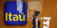 Uma mulher passa na frente de uma agência do Itaú no Rio de Janeiro. A ação do Itaú Unibanco superou o peso dos papéis da Petrobras na primeira prévia da nova carteira do Ibovespa, divulgada na manhã desta terça-feira. A prévia também traz de volta para o índice a mineradora MMX, informou a agência Bovespa. 29/01/2014  Foto: Sergio Moraes / Reuters