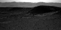 <p>Ponto luminoso aparece no fundo da foto, próximo às "montanhas", no horizonte de Marte</p>  Foto: Reprodução NASA
