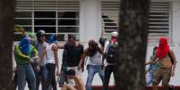 <p>Estudante é agredido e despido por partidários do governo de Nicolás Maduro, durante manifestação na Universidade Central da Venezuela, em Caracas</p>  Foto: AP