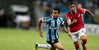 Dudu tenta armar jogada pelo Grêmio  Foto: AFP