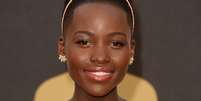 Lupita foi ao Oscar com a pele bem trabalhada, com poucos sinais de maquiagem, explica Anna. Esse efeito é obtido com uma base leve de acabamento translúcido. Nas maçãs, blush alaranjado (ótimo para peles negras), e iluminador suave no centro da testa e no queixo. Nos olhos, delineador marcado, do meio dos olhos para fora, máscara de cílios e batom rosado bem suave arrematado com gloss transparente.  Foto: Getty Images