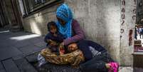 <p>Mulher síria  é vistacom os filhos na calçada, no centro de Istambul, nesta terça-feira, 22 de abril</p>  Foto: AFP