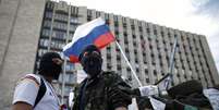 <p>Manifestantes pró-Rússia montam guarda perto de barricada montada em frente a um edifício do governo na cidade de Donetsk, em 23 de abril</p>  Foto: Reuters