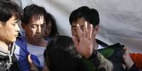 <p>Familiares&nbsp;de passageiros&nbsp;a bordo da balsa que naufragou na costa sul-coreana agrediram&nbsp;Choi Sang-hwan, vice-chefe da guarda costeira do pa&iacute;s (zom camisa azul)&nbsp;e um funcion&aacute;rio do governo (a direita),&nbsp;em Jindo, nesta quinta-feira, 24 de abril</p>  Foto: Reuters
