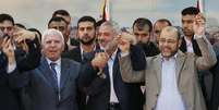 <p>Alto funcionário do Fatah, Azzam Al-Ahmed (a esquerda), chefe do governo do Hamas, Ismail Haniyeh (ao centro) e líder do Hamas Moussa Abu Marzouq seguram as mãos depois de anunciar um acordo de reconciliação na Cidade de Gaza, nesta quarta-feira, 23 de abril</p>  Foto: Reuters