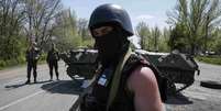 <p>Soldados ucranianos montam guarda perto de um ve&iacute;culo blindado em um posto de controle fora da cidade de Slaviansk, em 27 de abril</p>  Foto: Reuters