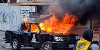 Grupo de jovens levantava barricada em uma rua próxima e, ao avistar o veículo estacionado, decidiu atear fogo à caminhonete  Foto: AFP