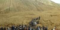 <p>Várias pessoas procuram por sobreviventes após o deslizamento de terra que soterrou sexta-feira o vilarejo de Abi-Barik, na província de Badakhshan, no norte do Afeganistão</p>  Foto: AP