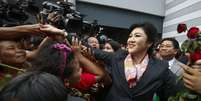 <p>A primeira-ministra da Tailândia, Yingluck Shinawatra, cumprimenta seus partidários ao sair do Escritório de Defesa de Bangock, em 7 de maio</p>  Foto: Reuters