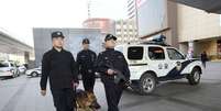 Policiais armados fazem patrulha com cão ao longo de uma área de negócios em Pequim nesta segunda-feira. A China reforçou a segurança na capital pela violência  Foto: Reuters