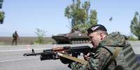 <p>Soldado ucraniano deixa sua arma em posição de tiro, em um posto de controle do exército, durante um referendo sobre a autonomia da Ucrânia </p>  Foto: Reuters