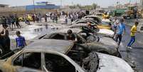 Pessoas se reúnem em local de ataque com carros-bomba no distrito de Sadr City em Bagdá; série de explosões em toda a capital iraquiana mataram 24 pessoas   Foto: Reuters