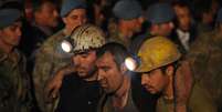 <p>Socorristas amparam vítima da explosão em mina da Turquia, nesta terça-feira</p>  Foto: Cihan