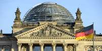 <p>Bandeira da Alemanha em frente ao Palácio do Parlamento Alemão; economia do país cresceu 0,1% no 3º trimestre deste ano, evitando a recessão</p>  Foto: Getty