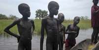 Meninos tentam vender peixes após a pesca em Nyal, Sudão do Sul  Foto: AP