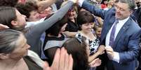 <p>Petro Poroshenko é aclamado pelo público, durante campanha, na Ucrânia. Mais de 50% dos ucranianos dizem que vão votar no magnata</p>  Foto: Reuters