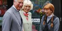 <p>Príncipe Charles e Camilla, duquesa da Cornoalha, ficam ao lado de uma jovem vestida como o personagem "Anne of Green Gables", em Charlottetown, no Canadá, em 20 de maio</p>  Foto: AFP