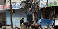 <p>Policiais paquistaneses inspecionam o local de uma explosão de bomba em Karachi, em 21 de maio</p>  Foto: AFP