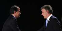 <p>Atual presidente da Colômbia e candidato presidencial, Juan Manuel Santos (direita) aperta a mão do candidato opositor Oscar Ivan Zuluaga durante um debate televisivo, em Bogotá, em 22 de maio </p>  Foto: Reuters