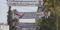 <p>Faixas com o rosto do atual presidente sírio, Bashar al-Assad, foram colocadas em ruas da cidade de Latika, em 24 de maio. As eleições presidenciais acontecem no dia 3 de junho</p>  Foto: AP