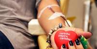 <p>Doador segura coração de vinil durante doação de sangue</p>  Foto: Facebook / Reprodução