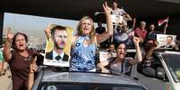 <p>Sírios que vivem no Líbano entoam hinos e carregam retratos de Bashar al-Assad enquanto dirigem em direção a embaixada síria em Beirute, em 28 de maio</p><p> </p>  Foto: AP