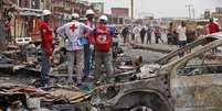 Equipe da Cruz Vermelha aparece em local onde carros-bomba explodiram em Jos, na Nigéria, em ataque no dia 21 de maio; extremistas do Boko Haram assumiram o controle de aldeias no nordeste da Nigéria  Foto: AP