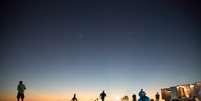 Equipe do Loon prepara o lançamento durante o amanhecer, enquanto ciclistas curiosos param para olhar  Foto: Google Loon / Divulgação