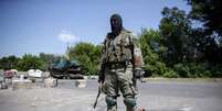 <p>Separatistas do leste afirmam que controlam entre 150 e 200 quil&ocirc;metros da fronteira entre Ucr&acirc;nia e R&uacute;ssia. Na foto, um&nbsp;rebelde pr&oacute;-R&uacute;ssia&nbsp;monta&nbsp;guarda em um posto de controle no leste da cidade ucraniana de Kramatorsk, em 4 de junho</p>  Foto: Reuters