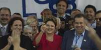 Dilma segura rosa vermelha, símbolo do partido  Foto: Marcelo Camargo / Agência Brasil