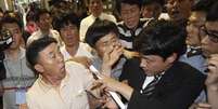 <p>Familiares de passageiros mortos no naufrágio da balsa Sewol discutem com agentes de segurança na tentativa de participar do julgamento de membros da tripulação, em 10 de junho</p>  Foto: AP