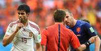 Após marcação de pênalti, Diego Costa faz sinal de silêncio enquanto jogador holandês reclama com árbitro  Foto: AFP