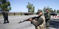 <p>O Exército informou que recuperou o controle da cidade de Mariupol. Na foto, um soldado ucraniano aponta sua arma em um posto de controle do Exército na cidade portuária, em 11 de maio</p>  Foto: Reuters