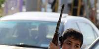 <p>Criança exibe arma em carro no Iraque</p>  Foto: Twitter