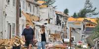 <p>Moradores da província canadense de Ontário caminham em meio a casas destruídas pelo tornado que atingiu a região</p>  Foto: Twitter
