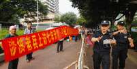 <p>Policiais impedem um&nbsp;jornalista de tirar fotos durante um protesto na frente do pr&eacute;dio do governo em Guangzhou, prov&iacute;ncia de Guangdong, em 16 de junho</p>  Foto: Reuters