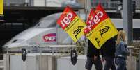 <p>Trabalhadores ferrovi&aacute;rios seguram bandeiras de protesto ao passar em frente a uma esta&ccedil;&atilde;o&nbsp;ferrovi&aacute;ria de Nantes, a oeste da Fran&ccedil;a</p>  Foto: Reuters