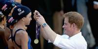Príncipe Harry distribuiu medalhas às crianças que se apresentaram nas piscinas  Foto: Getty Images 