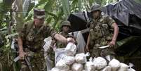 <p>Exército Mario Montoya (à esq.) examina um pacote de cocaína confiscado por tropas colombianas</p>  Foto: Eliana Aponte / Reuters