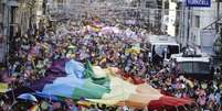 <p>Participantes agitam uma enorme bandeira do arco-íris durante a parada do orgulho gay no centro de Istambul, em 29 de junho</p>  Foto: Osman Orsal / Reuters