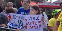 <p>Jovem Manuela foi recepcionar Neymar na Granja Comary com uma faixa mostrando amor pelo atleta</p>  Foto: Celso Paiva / Terra