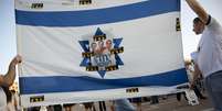 <p>No centro de uma bandeira de Israel, fotos dos três jovens desaparecidos são coladas em memória deles</p>  Foto: Oded Balilty / AP