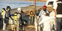 <p>Bombeiros recuperam&nbsp;um dos corpos encontrados em um barco de pesca que estava cheio&nbsp;de imigrantes, depois que a embarca&ccedil;&atilde;o&nbsp;foi rebocada&nbsp;pela Marinha italiana no porto siciliano de Pozzallo, em&nbsp;1&ordm; de julho</p>  Foto: Antonio Parrinello / Reuters