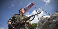 <p>Um separatista pró-Rússia monta guarda em um posto de controle rodoviário fora da cidade de Lysychansk, na região de Lugansk, em 24 de junho</p>  Foto: Shamil Zhumatov / Reuters