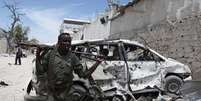 <p>Soldado do governo da Som&aacute;lia caminha ao lado de um carro danificado</p>  Foto: Omar Faruk / Reuters