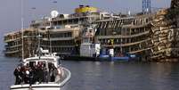 <p>Oficiais da Marinha levam uma coroa de flores ao Costa Concordia para marcar o segundo aniversário da tragédia na ilha de Giglio, em 13 de janeiro de 2014</p>  Foto: Max Rossi / Reuters