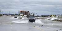 <p>Carros cruzam uma avenida alagada ap&oacute;s a passagem do furac&atilde;o Arthur em Nags Head, na Carolina do Norte, Estados Unidos, nessa sexta-feira</p>  Foto: Chris Keane / Reuters