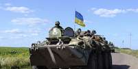Em imagem do dia 3 de julho, soldados ucranianos conduzem um tanque militar com uma bandeira da Ucrânia em um posto de controle perto de Slaviansk  Foto: Reuters